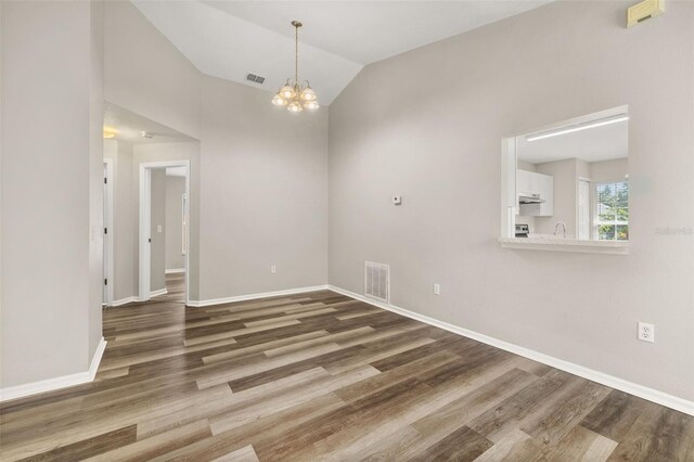 2146 Fish Eagle St, Clermont, FL 34714 - unfurnished room with wood finished floors, baseboards, a chandelier, and vaulted ceiling