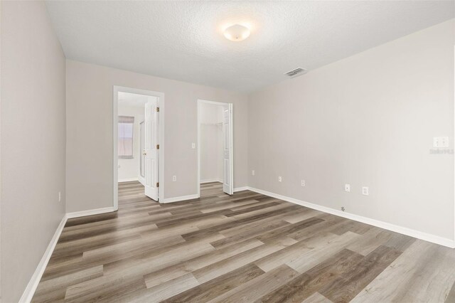 2146 Fish Eagle St, Clermont, FL 34714 - spare room with wood finished floors, baseboards, and a textured ceiling