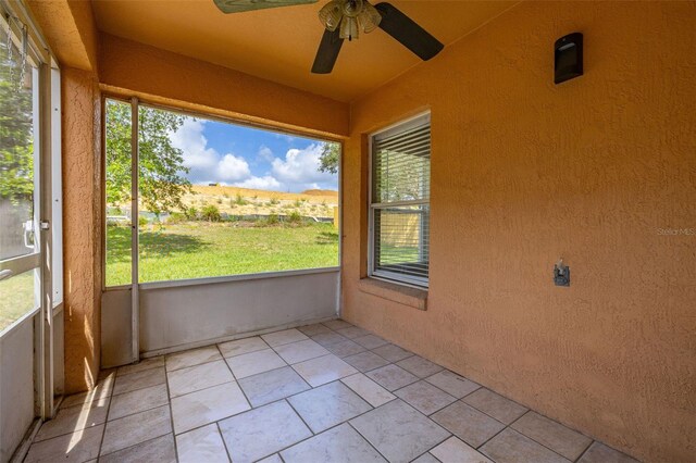 2146 Fish Eagle St, Clermont, FL 34714 - unfurnished sunroom featuring a ceiling fan and a textured wall