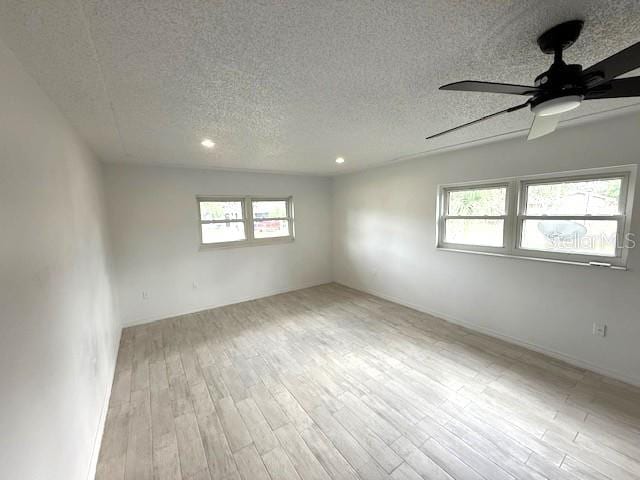 5249 SE 106th Ln, Belleview, FL 34420 - empty room with a textured ceiling, healthy amount of natural light, wood finished floors, ceiling fan, and recessed lighting