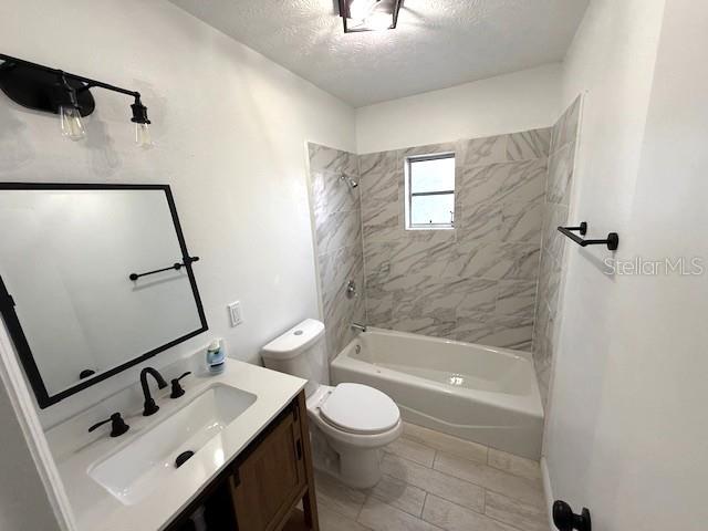 5249 SE 106th Ln, Belleview, FL 34420 - full bathroom with a textured ceiling, toilet, vanity, and bathing tub / shower combination