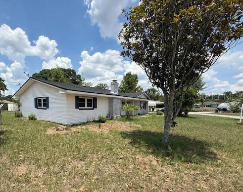 5249 SE 106th Ln, Belleview, FL 34420 - view of side of home featuring a chimney and a lawn