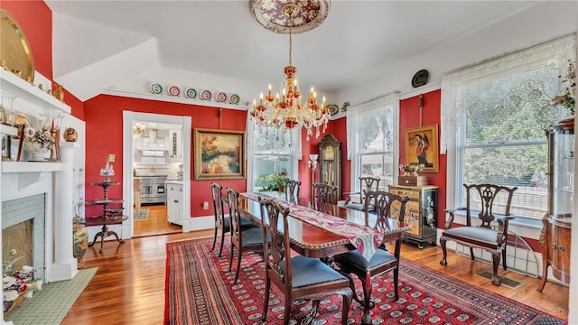 822 W Patterson St, Lakeland, FL 33803 - dining area with a chandelier, wood finished floors, and a fireplace with flush hearth