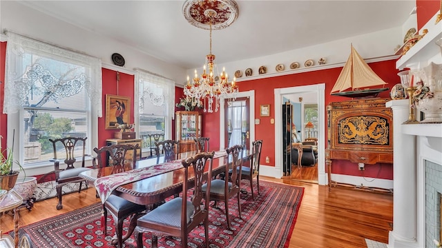 822 W Patterson St, Lakeland, FL 33803 - dining space with a chandelier, light wood finished floors, and a fireplace with flush hearth