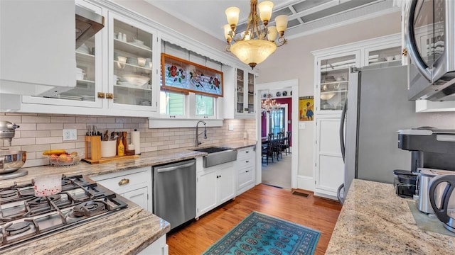 822 W Patterson St, Lakeland, FL 33803 - kitchen with appliances with stainless steel finishes, a sink, a chandelier, backsplash, and crown molding