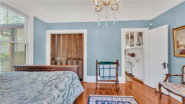 822 W Patterson St, Lakeland, FL 33803 - bedroom featuring light wood-style floors, a chandelier, crown molding, and baseboards