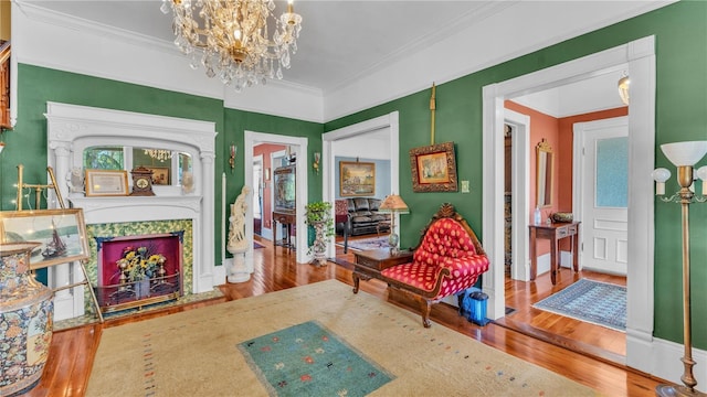 822 W Patterson St, Lakeland, FL 33803 - living area with hardwood / wood-style floors, a chandelier, crown molding, a fireplace with flush hearth, and baseboards