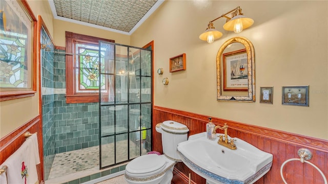 822 W Patterson St, Lakeland, FL 33803 - bathroom featuring a wainscoted wall, toilet, a tile shower, a sink, and crown molding