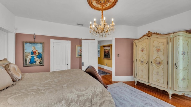 822 W Patterson St, Lakeland, FL 33803 - bedroom featuring a chandelier, wood finished floors, and baseboards