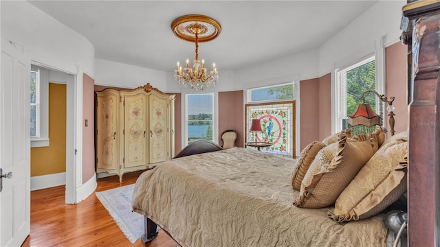 822 W Patterson St, Lakeland, FL 33803 - bedroom with a chandelier, light wood finished floors, and baseboards
