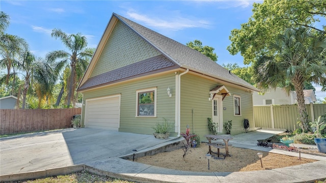 822 W Patterson St, Lakeland, FL 33803 - back of house featuring driveway, roof with shingles, and a garage