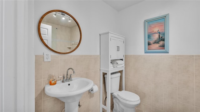 822 W Patterson St, Lakeland, FL 33803 - bathroom featuring tile walls, toilet, wainscoting, and a sink