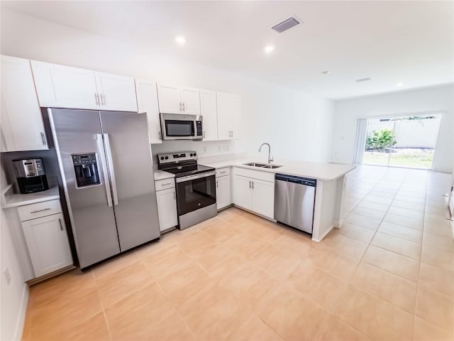 8540 Daybreak St, Sarasota, FL 34241 - kitchen featuring stainless steel appliances, a sink, a peninsula, light countertops, and white cabinetry