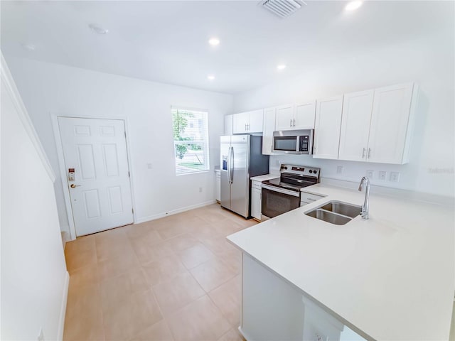 8540 Daybreak St, Sarasota, FL 34241 - kitchen with appliances with stainless steel finishes, a sink, light countertops, white cabinets, and a peninsula