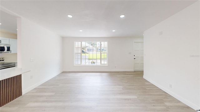3621 Devonswood Dr, Orlando, FL 32806 - unfurnished living room with light wood-style floors, recessed lighting, and baseboards
