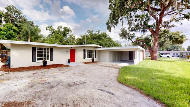 3621 Devonswood Dr, Orlando, FL 32806 - ranch-style home featuring asphalt driveway, a front lawn, and a carport
