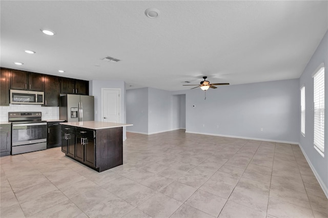 4492 Bluff Oak Loop, Kissimmee, FL 34746 - kitchen with appliances with stainless steel finishes, a ceiling fan, light countertops, tasteful backsplash, and a kitchen island