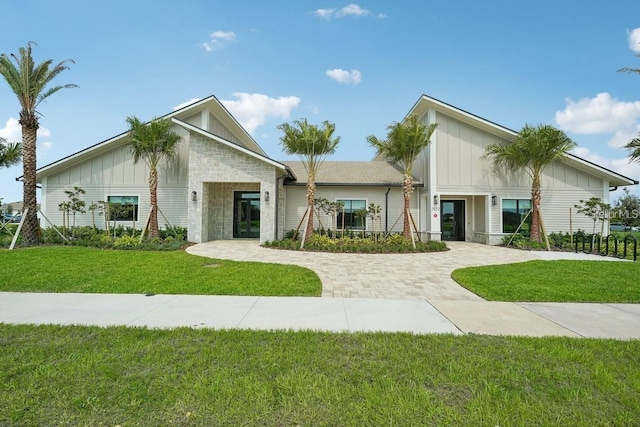 4492 Bluff Oak Loop, Kissimmee, FL 34746 - view of front of home featuring board and batten siding, a front lawn, and stone siding