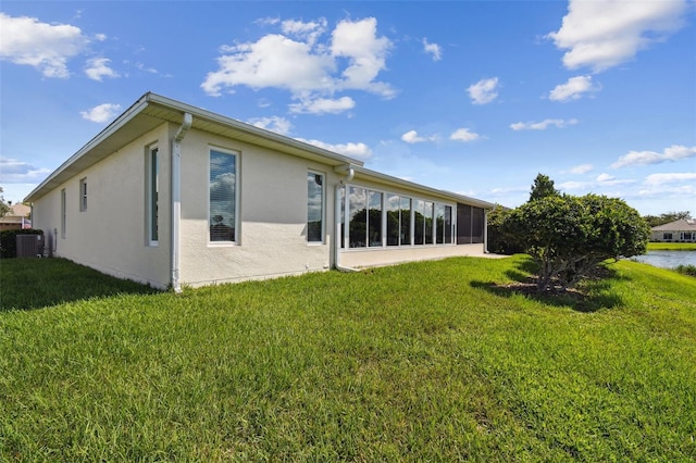201 Largo Dr, Kissimmee, FL 34759 - back of property with a lawn, stucco siding, a water view, and a sunroom