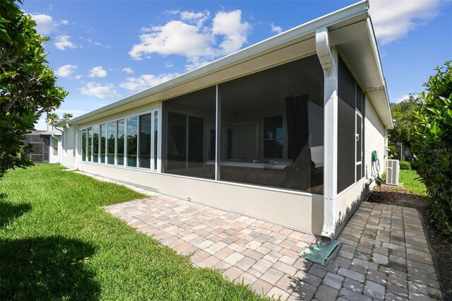 201 Largo Dr, Kissimmee, FL 34759 - rear view of house featuring a sunroom, a lawn, and stucco siding