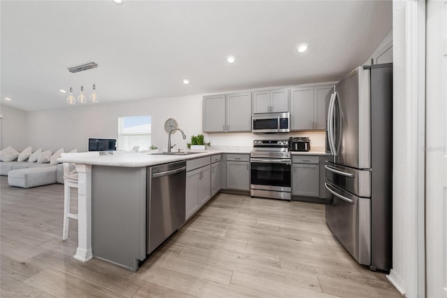 1719 Daystar Dr, Haines City, FL 33844 - kitchen featuring stainless steel appliances, gray cabinetry, open floor plan, a peninsula, and light countertops