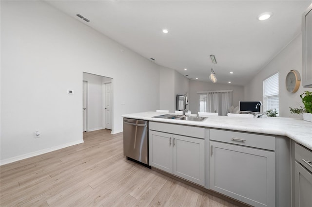 1719 Daystar Dr, Haines City, FL 33844 - kitchen with stainless steel dishwasher, gray cabinets, light countertops, light wood-style floors, and a peninsula