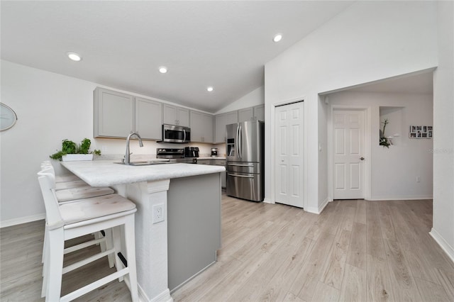 1719 Daystar Dr, Haines City, FL 33844 - kitchen with appliances with stainless steel finishes, gray cabinetry, light countertops, a peninsula, and a kitchen breakfast bar