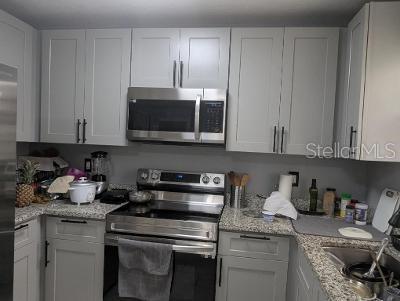 946 Delano Ct, Kissimmee, FL 34758 - kitchen with appliances with stainless steel finishes, white cabinetry, light stone counters, and a sink
