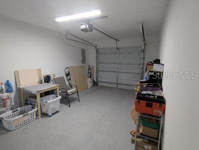 946 Delano Ct, Kissimmee, FL 34758 - garage featuring a garage door opener and electric panel