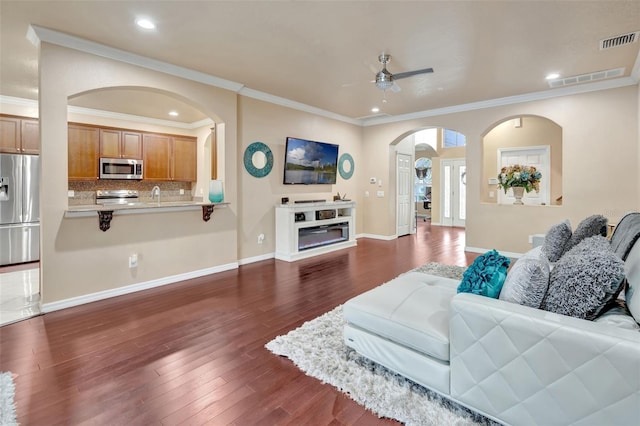 6932 Gray Catbird Loop, Wesley Chapel, FL 33545 - living room with ceiling fan, arched walkways, dark wood-type flooring, crown molding, and recessed lighting