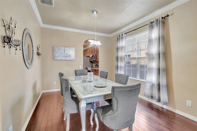 6932 Gray Catbird Loop, Wesley Chapel, FL 33545 - dining space with dark wood finished floors, arched walkways, and ornamental molding
