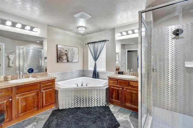 6932 Gray Catbird Loop, Wesley Chapel, FL 33545 - bathroom featuring a shower stall, two vanities, a bath, a textured ceiling, and marble finish floors