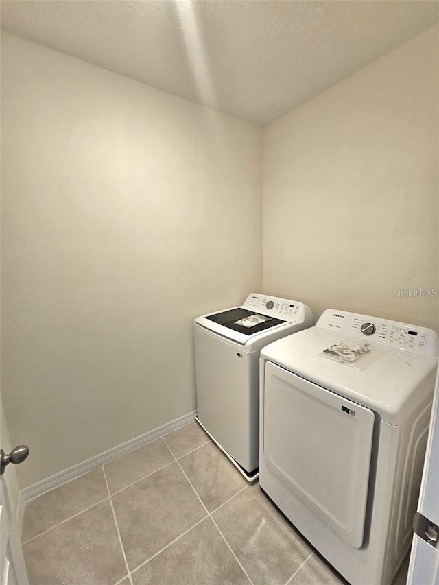 3886 Whitney Way, Haines City, FL 33844 - washroom featuring washer and dryer, light tile patterned floors, baseboards, and a textured ceiling