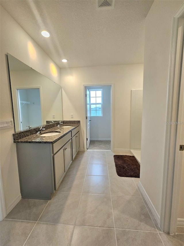 3886 Whitney Way, Haines City, FL 33844 - full bath with double vanity, a textured ceiling, baseboards, recessed lighting, and tile patterned flooring