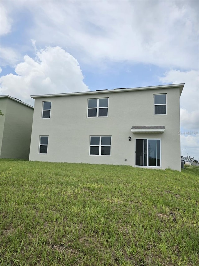 3886 Whitney Way, Haines City, FL 33844 - back of house featuring stucco siding and a yard