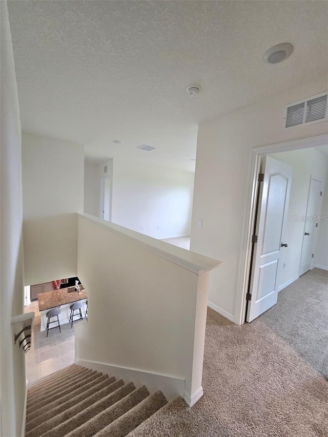 3886 Whitney Way, Haines City, FL 33844 - stairs featuring carpet flooring and a textured ceiling