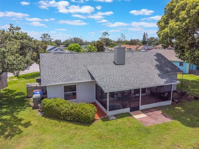 1631 Woodbay Ct, Kissimmee, FL 34744 - back of house with roof with shingles, a sunroom, a lawn, and a chimney