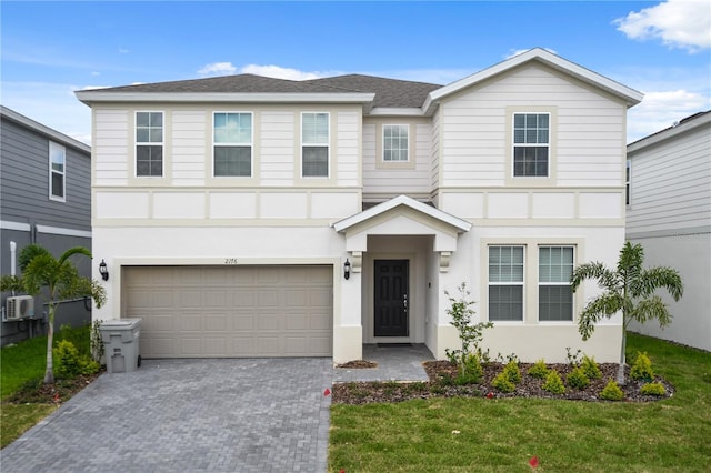2176 Lelani Cir, Davenport, FL 33897 - view of front of home with decorative driveway, a garage, a front yard, and stucco siding