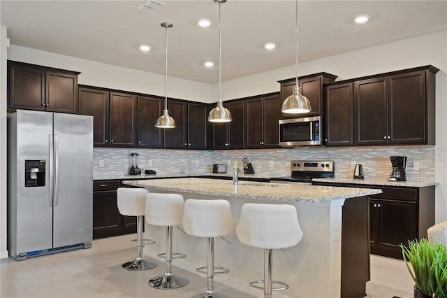 2176 Lelani Cir, Davenport, FL 33897 - kitchen with appliances with stainless steel finishes, light stone countertops, tasteful backsplash, dark brown cabinets, and recessed lighting