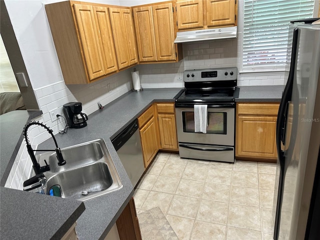 3301 Soho St Unit 104, Orlando, FL 32835 - kitchen with under cabinet range hood, stainless steel appliances, dark countertops, and backsplash