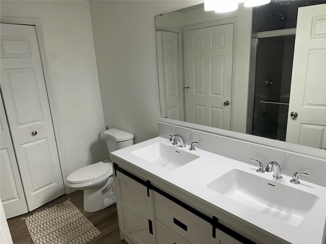 3301 Soho St Unit 104, Orlando, FL 32835 - full bath featuring double vanity, a shower with shower door, toilet, wood finished floors, and a closet