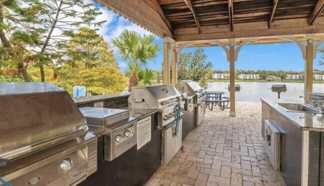 1023 S Hiawassee Rd Unit 4017, Orlando, FL 32835 - view of patio with an outdoor kitchen and a water view