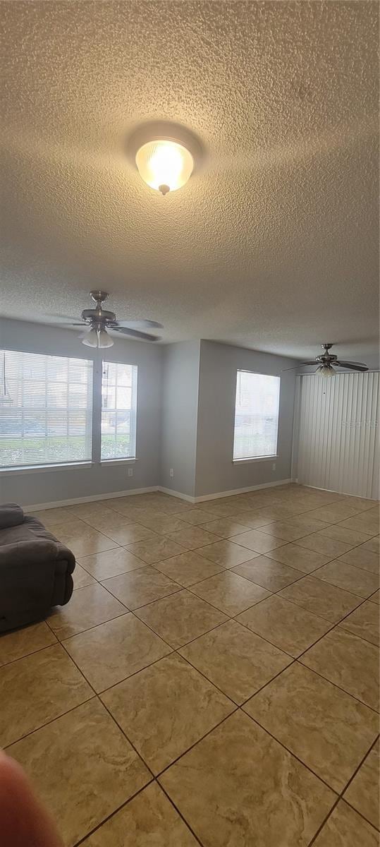 1023 S Hiawassee Rd Unit 4017, Orlando, FL 32835 - tiled empty room with a textured ceiling, baseboards, and ceiling fan