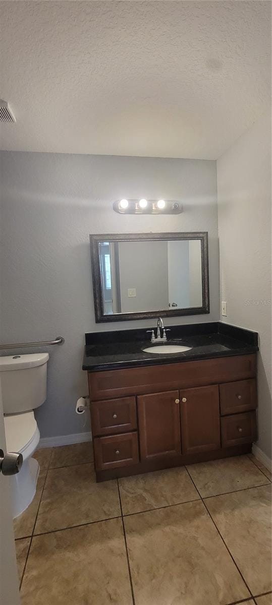 1023 S Hiawassee Rd Unit 4017, Orlando, FL 32835 - bathroom with vanity, tile patterned flooring, a textured ceiling, baseboards, and toilet