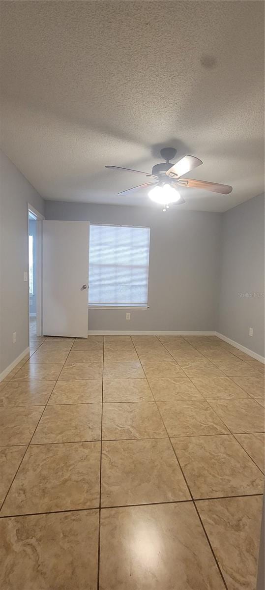 1023 S Hiawassee Rd Unit 4017, Orlando, FL 32835 - empty room featuring ceiling fan, light tile patterned floors, a textured ceiling, and healthy amount of natural light