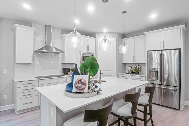 222 Thornberry Way, Palm Coast, FL 32164 - kitchen with stainless steel appliances, wall chimney range hood, light wood-style floors, tasteful backsplash, and white cabinets
