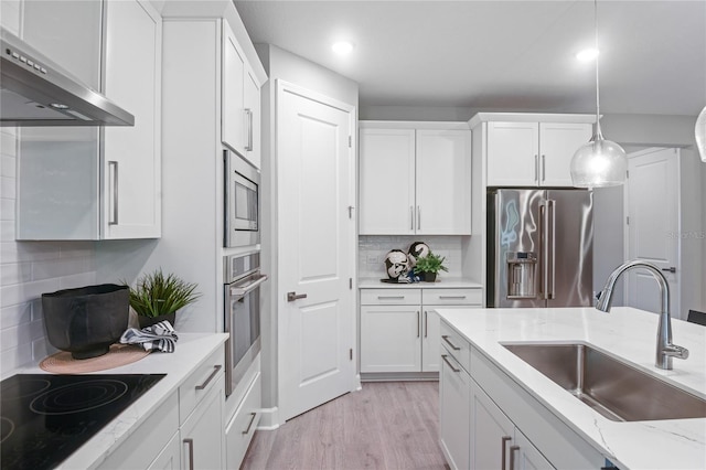 222 Thornberry Way, Palm Coast, FL 32164 - kitchen with appliances with stainless steel finishes, wall chimney range hood, white cabinetry, decorative backsplash, and recessed lighting