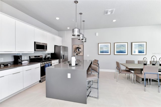 7770 Sandy Ridge Dr Unit 142, Kissimmee, FL 34747 - kitchen featuring appliances with stainless steel finishes, a kitchen breakfast bar, white cabinets, a center island with sink, and modern cabinets