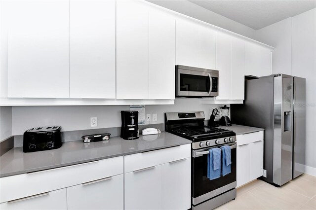 7770 Sandy Ridge Dr Unit 142, Kissimmee, FL 34747 - kitchen featuring stainless steel appliances, white cabinetry, and light tile patterned flooring