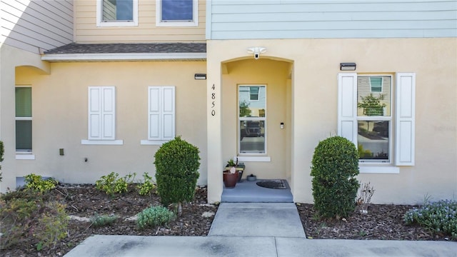 4850 Coral Castle Dr, Kissimmee, FL 34746 - property entrance featuring a shingled roof and stucco siding